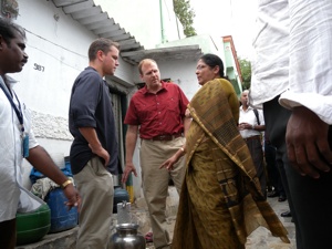 Water.org co-founders Gary White and Matt Damon discuss the water crisis with Mrs. T. Nanda Vardhan, secretary with Water.orgs local partner SIDUR, in a slum of Hyderabad, India.
